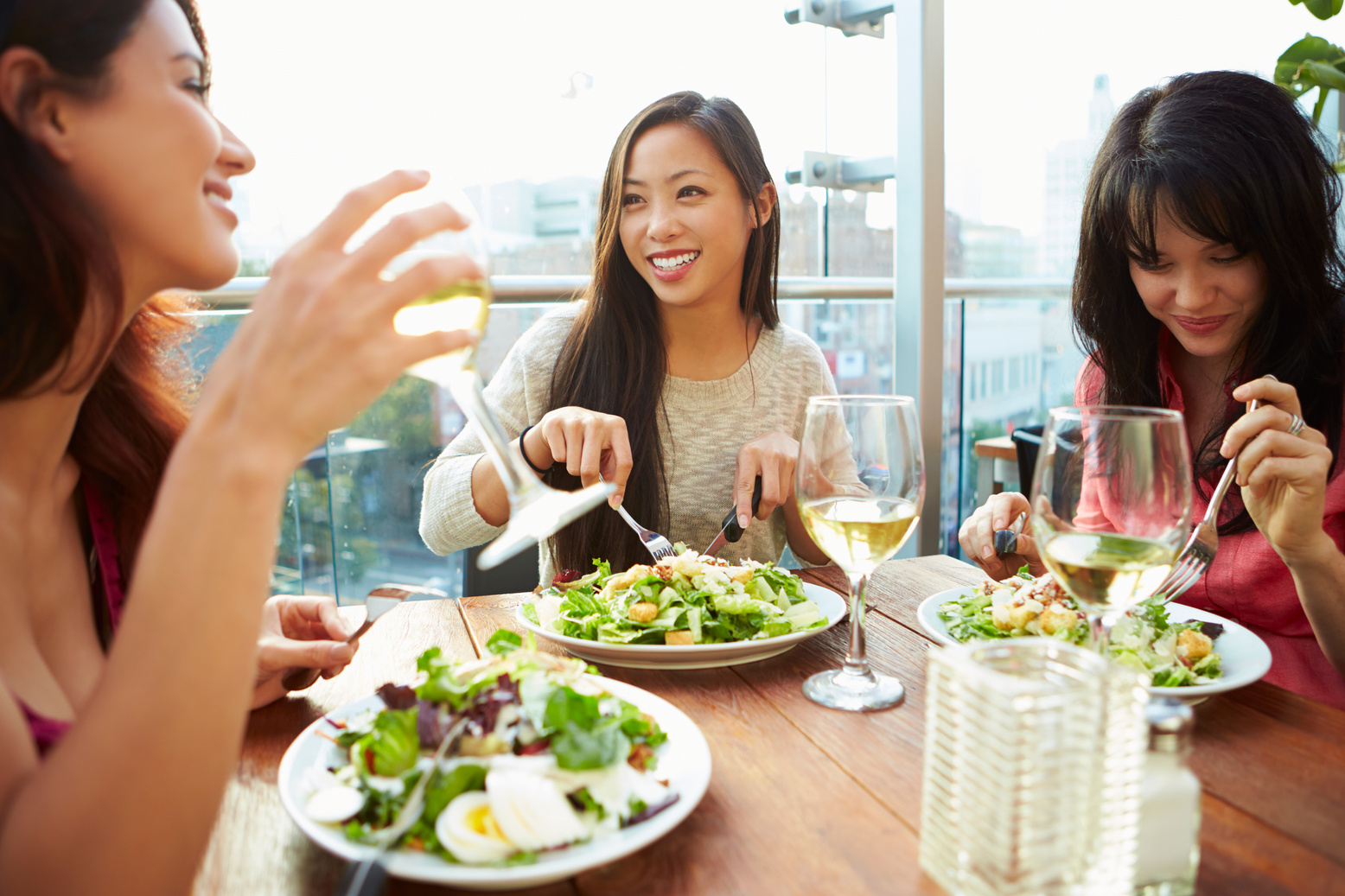 Three Female Friends Enjoying Lunch at Rooftop Restaurant